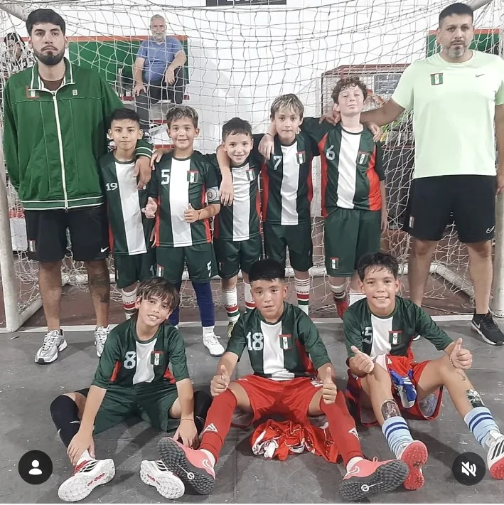 Plantel infantil y entrenadores frente a un arco